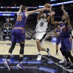 San Antonio Spurs guard Tony Parker (9) is blocked by Phoenix Suns forward Dragan Bender (35) as he drives in to score during the first half of an NBA basketball game, Wednesday, Dec. 28, 2016, in San Antonio. (AP Photo/Eric Gay)