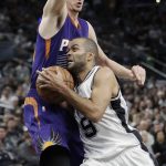 San Antonio Spurs guard Tony Parker (9) is defended by Phoenix Suns forward Dragan Bender (35) as he drives in for a shot during the first half of an NBA basketball game, Wednesday, Dec. 28, 2016, in San Antonio. (AP Photo/Eric Gay)