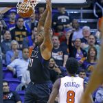 Phoenix Suns forward P.J. Tucker, left, dunks on a fast break as he gets past New York Knicks guard Justin Holiday (8) during the first half of an NBA basketball game, Tuesday, Dec. 13, 2016, in Phoenix. (AP Photo/Ross D. Franklin)