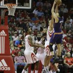 Phoenix Suns guard Devin Booker (1) shoots over Houston Rockets forward Ryan Anderson (3) as forward Trevor Ariza (1) watches in the first half of an NBA basketball game on Monday, Dec. 26, 2016 in Houston. (AP Photo/Bob Levey)