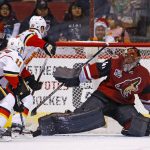 Calgary Flames center Mikael Backlund (11) scores a goal against Arizona Coyotes goalie Mike Smith (41) as Flames center Sam Bennett (93) creates a screen during the second period of an NHL hockey game Monday, Dec. 19, 2016, in Glendale, Ariz. (AP Photo/Ross D. Franklin)