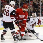Arizona Coyotes goalie Mike Smith (41) stops a shot as Detroit Red Wings center Riley Sheahan (15) waits for the rebound and Michael Stone (26) defends in the second period of an NHL hockey game Tuesday, Dec. 13, 2016, in Detroit. (AP Photo/Paul Sancya)