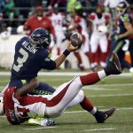 Seattle Seahawks quarterback Russell Wilson tries to pass while being brought down by Arizona Cardinals' Sio Moore in the second half of an NFL football game, Saturday, Dec. 24, 2016, in Seattle. (AP Photo/Ted S. Warren)