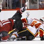 Arizona Coyotes center Martin Hanzal (11) flips over Calgary Flames right wing Garnet Hathaway (64) as the two collide on the ice during the first period of an NHL hockey game Thursday, Dec. 8, 2016, in Glendale, Ariz. (AP Photo/Ross D. Franklin)