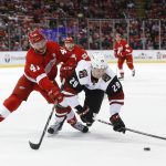 Detroit Red Wings center Luke Glendening (41) knocks Arizona Coyotes left wing Brendan Perlini (29) off the puck in the third period of an NHL hockey game, Tuesday, Dec. 13, 2016, in Detroit. (AP Photo/Paul Sancya)