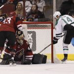 Dallas Stars' Jamie Benn (14) slips the puck past the pad of Arizona Coyotes goalie Mike Smith (41) for a goal as Coyotes defenseman Alex Goligoski (33) skates in during the second period of an NHL hockey game, Tuesday, Dec. 27, 2016, in Glendale, Ariz. (AP Photo/Ralph Freso)