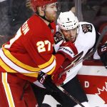 Arizona Coyotes' Tobias Rieder, right, from Germany, battles with Calgary Flames' Dougie Hamilton during the first period of an NHL game in Calgary, Alberta, Saturday, Dec. 31, 2016. (Larry MacDougal/The Canadian Press via AP)