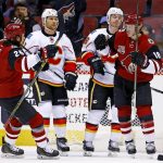 Arizona Coyotes center Christian Dvorak (18) celebrates his goal with center Ryan White (25) as Calgary Flames defenseman Dennis Wideman, second from left, and center Matt Stajan, second from right, look on during a first period of an NHL hockey game Monday, Dec. 19, 2016, in Glendale, Ariz. (AP Photo/Ross D. Franklin)