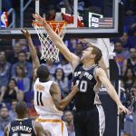 San Antonio Spurs forward David Lee (10) alters the shot of Phoenix Suns guard Brandon Knight (11) as Spurs guard Jonathon Simmons (17) looks on during the first half of an NBA basketball game Thursday, Dec. 15, 2016, in Phoenix. (AP Photo/Ross D. Franklin)