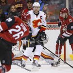 Calgary Flames defenseman Mark Giordano (5) takes a slapshot off his stomach from Arizona Coyotes defenseman Michael Stone (26) as Coyotes' right wing Tobias Rieder (8) looks for a possible rebound during the first period of an NHL hockey game Thursday, Dec. 8, 2016, in Glendale, Ariz. (AP Photo/Ross D. Franklin)