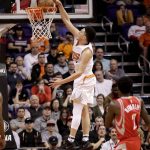Phoenix Suns guard Devin Booker (1) dunks as Houston Rockets guard Patrick Beverley (2) watches during the first half of an NBA basketball game, Wednesday, Dec. 21, 2016, in Phoenix. (AP Photo/Matt York)