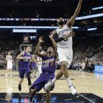 San Antonio Spurs guard Patty Mills (8) scores past Phoenix Suns guard Brandon Knight (11) during the first half of an NBA basketball game, Wednesday, Dec. 28, 2016, in San Antonio. (AP Photo/Eric Gay)
