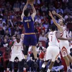 Phoenix Suns guard Devin Booker (1) shoots over Houston Rockets forward Trevor Ariza (1) and forward Ryan Anderson (3) in the first half of an NBA basketball game on Monday, Dec. 26, 2016 in Houston. (AP Photo/Bob Levey)