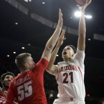 Arizona center Chance Comanche (21) shoots over New Mexico forward Connor MacDougall during the second half of an NCAA college basketball game, Tuesday, Dec. 20, 2016, in Tucson, Ariz. (AP Photo/Rick Scuteri)