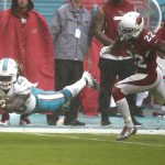 Miami Dolphins running back Jay Ajayi (23) attempts to make a catch as Arizona Cardinals strong safety Tony Jefferson (22) is late with the tackle, during heavy rain in the first half of an NFL football game, Sunday, Dec. 11, 2016, in Miami Gardens, Fla. (AP Photo/Wilfredo Lee)