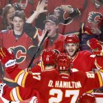 Calgary Flames' Michael Frolik, right, from Czech Republic, celebrates his goal with Mikael Backlund, left, from Sweden and Dougie Hamilton against the Arizona Coyotes during the first period of an NHL game in Calgary, Alberta, Saturday, Dec. 31, 2016. (Larry MacDougal/The Canadian Press via AP)