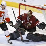 Arizona Coyotes goalie Mike Smith, right, makes a save on a redirect from Calgary Flames left wing Matthew Tkachuk (19) during the second period of an NHL hockey game Thursday, Dec. 8, 2016, in Glendale, Ariz. (AP Photo/Ross D. Franklin)