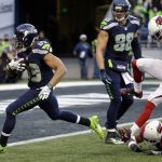 Seattle Seahawks' Doug Baldwin runs in for a touchdown on a pass reception as Arizona Cardinals' Brandon Williams (26) and Justin Bethel (28) follow in the second half of an NFL football game, Saturday, Dec. 24, 2016, in Seattle. (AP Photo/Ted S. Warren)