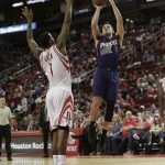 Phoenix Suns guard Devin Booker (1) shoots a fadeaway over Houston Rockets forward Trevor Ariza (1) in the second half of an NBA basketball game on Monday, Dec. 26, 2016 in Houston. Houston won 131-115. (AP Photo/Bob Levey)