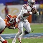 Ohio State quarterback J.T. Barrett (16) eludes the reach of Clemson defensive end Clelin Ferrell (99) during the first half of the Fiesta Bowl NCAA college football playoff game, Saturday, Dec. 31, 2016, in Glendale, Ariz. (AP Photo/Ross D. Franklin)