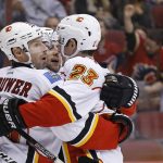 Calgary Flames defenseman Mark Giordano celebrates his goal against the Arizona Coyotes with center Sean Monahan (23) and right wing Troy Brouwer, left, during the first period of an NHL hockey game Thursday, Dec. 8, 2016, in Glendale, Ariz. (AP Photo/Ross D. Franklin)