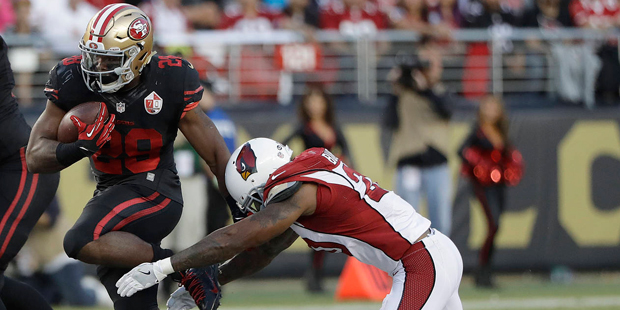 San Francisco 49ers running back Carlos Hyde (28) tries to get away from Arizona Cardinals strong s...