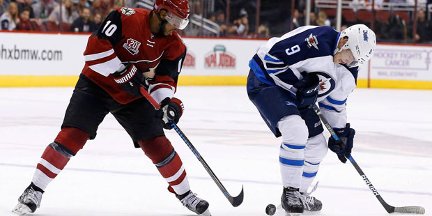 Winnipeg Jets center Andrew Copp (9) competes with Arizona Coyotes left wing Anthony Duclair (10) f...