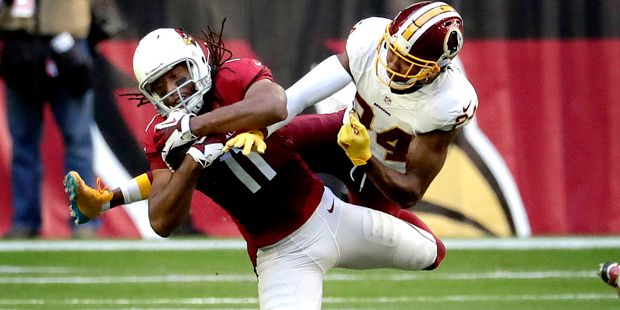 In this photo taken Dec. 4, 2016, Arizona Cardinals wide receiver Larry Fitzgerald (11) is hit by W...