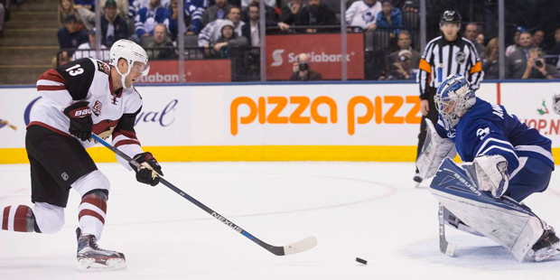 Arizona Coyotes' Peter Holland, left, scores against Toronto Maple Leafs goalie Frederik Andersen d...