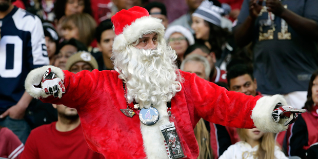 An Arizona Cardinals fan dressed as Santa Claus cheers after an NFL football game against the New O...
