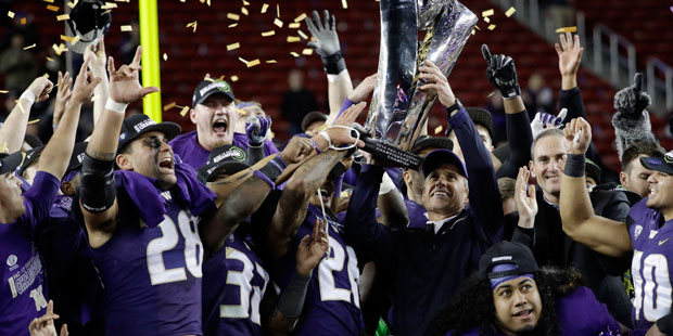 Washington coach Chris Petersen holds the trophy after Washington's 41-10 win over Colorado in the ...