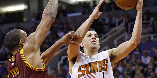 Phoenix Suns guard Devin Booker (1) drives past Cleveland Cavaliers forward Channing Frye (8) durin...