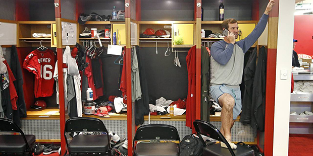 Arizona Cardinals quarterback Drew Stanton pauses on his cellphone as he cleans out his locker afte...