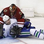 Vancouver Canucks left wing Sven Baertschi (47) crashes into Arizona Coyotes goalie Mike Smith (41) during the second period of an NHL hockey game Thursday, Jan. 26, 2017, in Glendale, Ariz. (AP Photo/Ross D. Franklin)
