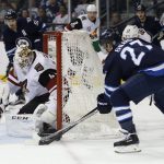 Arizona Coyotes goaltender Mike Smith (41) saves the wraparound attempt by Winnipeg Jets' Nikolaj Ehlers (27) as Coyotes' Oliver Ekman-Larsson (23) defends during the second period of an NHL hockey game Wednesday, Jan. 18, 2017, in Winnipeg, Manitoba. (John Woods/The Canadian Press via AP)