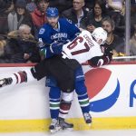 Arizona Coyotes left wing Lawson Crouse (67) goes into the boards with Vancouver Canucks defenseman Christopher Tanev (8) during the third period of an NHL hockey game in Vancouver, British Columbia, Wednesday, Jan. 4, 2017. (Jonathan Hayward/The Canadian Press via AP)