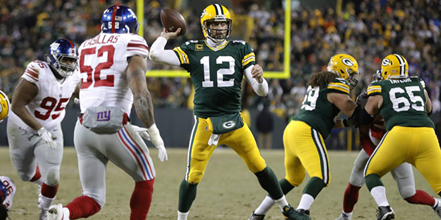 Green Bay Packers quarterback Aaron Rodgers (12) throws a touchdown pass during the first half of a...