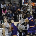 San Antonio Spurs Dewayne Dedmon . second right, goes for a rebound against Phoenix Suns Tyson Chandler, right, in the second half of their regular-season NBA basketball game in Mexico City, Saturday, Jan. 14, 2017. (AP Photo/Rebecca Blackwell)