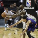 San Antonio Spurs Jonathon Simmons, back, fights for the ball with Phoenix Suns Devin Booker in the first half of their regular-season NBA basketball game in Mexico City, Saturday, Jan. 14, 2017. (AP Photo/Rebecca Blackwell)