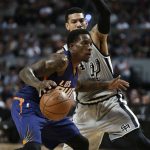 Phoenix Suns Eric Bledsoe, left, dribbles the ball as San Antonio Spurs Danny Green follows him, in the first half of their regular-season NBA basketball game in Mexico City, Saturday, Jan. 14, 2017. (AP Photo/Rebecca Blackwell)
