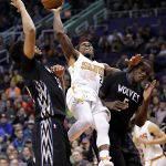 Phoenix Suns guard Eric Bledsoe (2) is fouled by Minnesota Timberwolves forward Gorgui Dieng (5) as center Karl-Anthony Towns (32) defends during the second half of an NBA basketball game, Tuesday, Jan. 24, 2017, in Phoenix. The Timberwolves won 112-111. (AP Photo/Matt York)