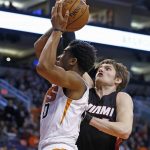Phoenix Suns forward Marquese Chriss (0) gets fouled by Miami Heat forward Luke Babbitt, right, as he goes up for a shot during the first half of an NBA basketball game Tuesday, Jan. 3, 2017, in Phoenix. (AP Photo/Ross D. Franklin)