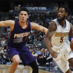Denver Nuggets guard Will Barton, right, drives to the net past Phoenix Suns guard Devin Booker in the first half of an NBA basketball game Thursday, Jan. 26, 2017, in Denver. (AP Photo/David Zalubowski)