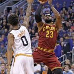 Cleveland Cavaliers forward LeBron James (23) shoots over Phoenix Suns forward Marquese Chriss (0) during the first half of an NBA basketball game Sunday, Jan. 8, 2017, in Phoenix. (AP Photo/Ross D. Franklin)