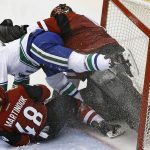 Arizona Coyotes left wing Jordan Martinook (48) and Vancouver Canucks right wing Jack Skille (9) crash in to Coyotes goalie Mike Smith, right, during the second period of an NHL hockey game Thursday, Jan. 26, 2017, in Glendale, Ariz. (AP Photo/Ross D. Franklin)