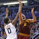Cleveland Cavaliers forward Kevin Love, right, gets off a shot over Phoenix Suns forward Marquese Chriss, left, during the first half of an NBA basketball game Sunday, Jan. 8, 2017, in Phoenix. (AP Photo/Ross D. Franklin)