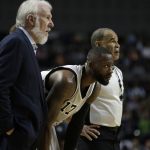 San Antonio Spurs head coach Gregg Popovic, left, gives instructions to San Antonio Spurs Jonathon Simmons, center, in the first half of their regular-season NBA basketball game in Mexico City, Saturday, Jan. 14, 2017. (AP Photo/Rebecca Blackwell)