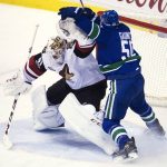 Vancouver Canucks center Brendan Gaunce (50) collides with Arizona Coyotes goalie Mike Smith (41) during the first period of an NHL hockey game in Vancouver, British Columbia, Wednesday, Jan. 4, 2017. (Jonathan Hayward/The Canadian Press via AP)