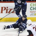 Winnipeg Jets' Andrew Copp (9) attempts to clear the puck as teammate Blake Wheeler (26) and Arizona Coyotes' Brendan Perlini (29) watch during the first period of an NHL hockey game Wednesday, Jan. 18, 2017, in Winnipeg, Manitoba. (John Woods/The Canadian Press via AP)