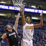 Phoenix Suns forward Marquese Chriss (0) gets off a shot over Miami Heat forward Luke Babbitt (5) during the first half of an NBA basketball game Tuesday, Jan. 3, 2017, in Phoenix. (AP Photo/Ross D. Franklin)